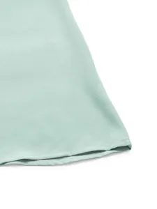 Dettaglio dell'orlo dell'abito verde menta con trama tessuta e cuciture di alta qualità