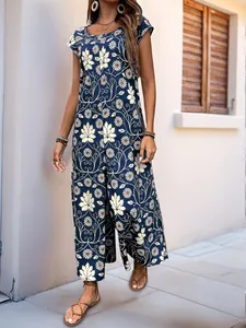 Detail of bohemian navy blue wide-leg jumpsuit with white daisy and maple leaf patterns