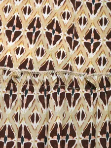 Detail showing geometric diamond print rayon fabric with smocked elastic stitching details