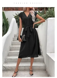 Détail de la robe noire évasée à col en V avec une ceinture à nouer assortie à la taille