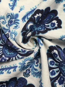 Détail macro du tissu à imprimé fleuri paisley bleu avec drapé élégant et texture douce
