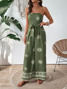 Olive green tube top jumpsuit with white floral patterns and tie-waist detail