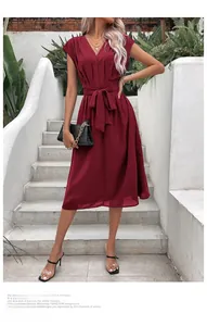 Détail du col en V et du nœud élégant à la taille sur une robe trapèze de couleur bordeaux