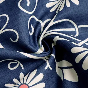 Macro shot of dark blue floral print fabric with white daisy patterns and scroll textures