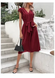 Détail de l'élégant col en V et du nœud à la taille de la robe mi-longue bordeaux