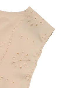 Détail de la veste beige montrant la broderie anglaise florale et les motifs ajourés
