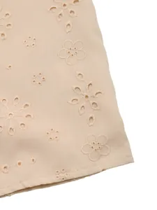 Vue macro détaillée du tissu broderie anglaise abricot avec des motifs floraux élégants