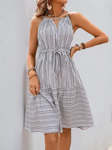 Détail de robe d'été rayée avec décolleté en V, col licou et taille à cordon de serrage