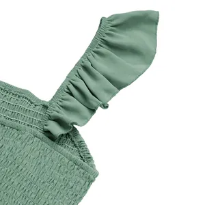Detailed view of ruffled shoulder straps and smocked texture on sage green summer set