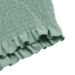 Detail view of sage green smocked fabric with ruffled hem on casual two-piece set