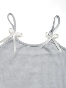 Detail of light gray ribbed tank top featuring delicate white satin bow accents