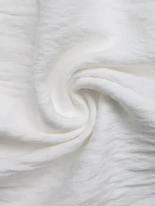 Close-up of white V-neck blouse fabric showing soft textured crepe chiffon details