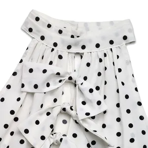 Detail of polka dot dress featuring a halter neck and chic front bow tie fastenings