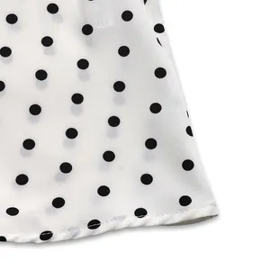 Detailed macro view of white polka dot fabric texture and precision hem stitching detail