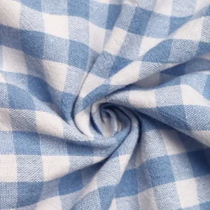 Détail macro du tissu à carreaux vichy bleu et blanc montrant le tissage et le drapé doux