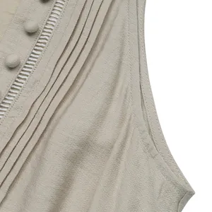 Detail of pintuck pleats and ladder lace on a beige V-neck sleeveless summer dress