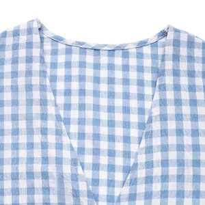 Détail d'une chemise d'été à carreaux vichy bleu et blanc avec coutures du col en V