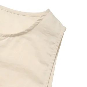 Close-up detail of beige cotton linen dress showing round neckline and fine stitching