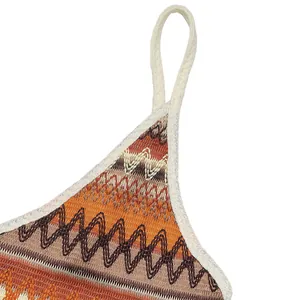 Close-up of zigzag knit fabric on bohemian dress featuring orange and brown wavy patterns