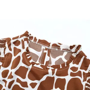 Detail of giraffe print shirt featuring ruffled neckline and droplet-style back slit closure