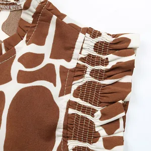 Detailed view of animal print blouse featuring smocking pleats and ruffled collar edges