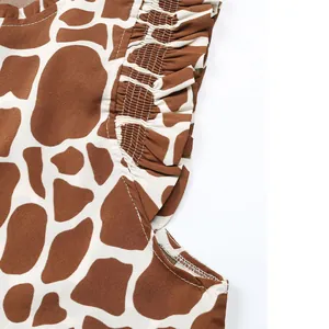Close-up of giraffe print fabric with delicate smocking and ruffled flutter sleeve edges