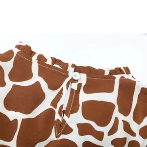 Close-up of giraffe print ruffled neck with back button closure on women's blouse