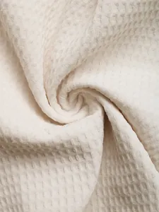 Macro view showing the detailed white waffle weave texture and premium fabric of the romper