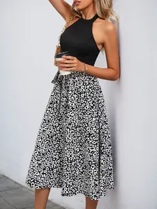 Detail of black halter knit top and black-and-white leopard print high waist midi skirt