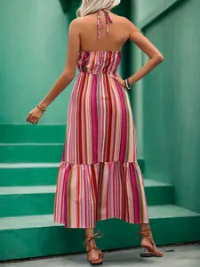 Back view of a halter neck striped maxi dress with colorful stripes and tiered ruffle hem