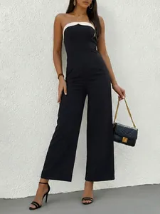 Detail of elegant black strapless jumpsuit with white contrast trim and wide leg design