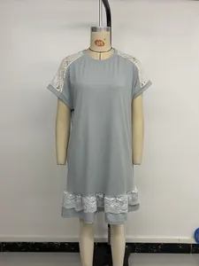 Détail d'une robe grise à manches courtes avec dentelle blanche délicate et ourlet volanté