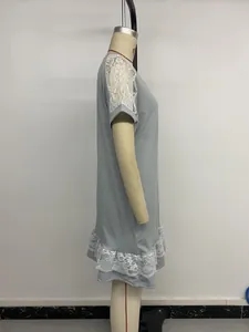 Détail de la dentelle florale blanche sur l'épaule et l'ourlet de la robe grise