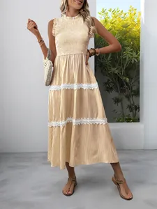 Detail of yellow striped sleeveless maxi dress featuring a smocked bodice and lace trim