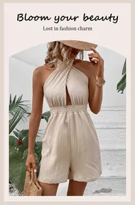 Detail van een crèmekleurige halter-romper met gekruiste halslijn en geplooide textuur