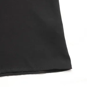 Detailed close-up of the black twill fabric texture and clean hemline stitching on dress