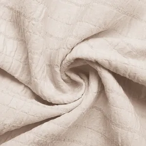Dettaglio del tessuto seersucker beige con trama stropicciata morbida e lino di cotone fresco
