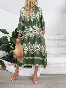 Close-up of bohemian dark green dress featuring ethnic prints and v-neckline detail