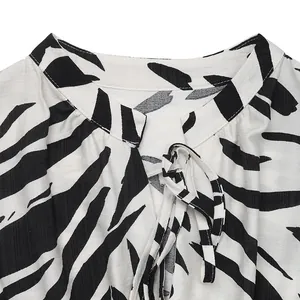 Detail of zebra print sleeveless dress featuring a stand collar and elegant neck tie