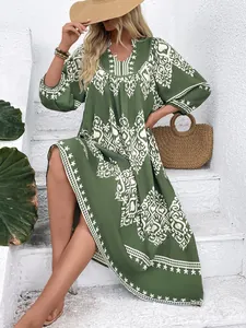 Detail of bohemian dark green maxi dress with white geometric vintage tribal patterns