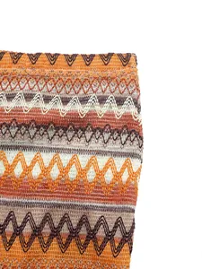 Detailed close-up of zigzag knitted fabric texture in orange and brown summer tones