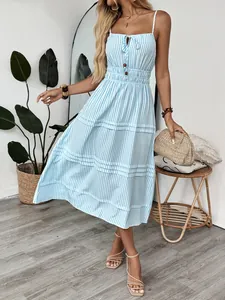 Robe d'été à rayures bleues et blanches avec fines bretelles et jupe à plusieurs niveaux