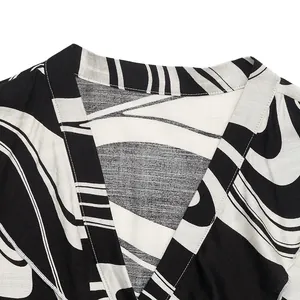 Macro shot of V-neckline featuring black and white abstract curved stripes and stitching