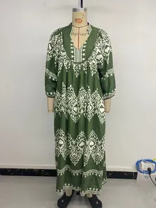 Close-up of dark green bohemian dress with white geometric prints and V-neckline
