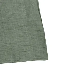 Detail shot of pleated lotus leaf sleeve and hemline on the sage green summer dress