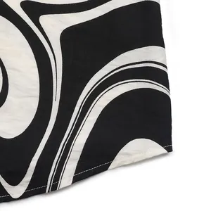 Detailed view of black and white abstract swirl print fabric with neat single-needle hem stitching
