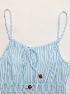 Détail de robe d'été rayée bleue avec col à nouer et perles en bois décoratives