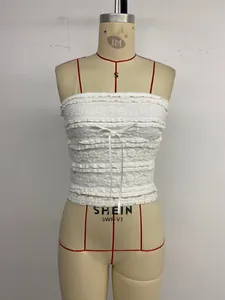 Vue détaillée d'un top bustier en dentelle blanche avec volants et petit nœud