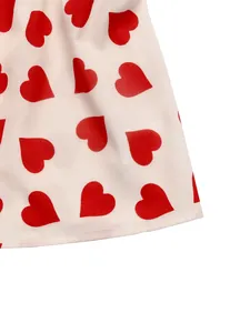 Detailed close-up of red heart print on white cotton fabric with neat hem stitching