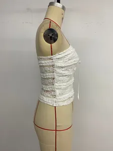 Détail d'un haut bandeau en dentelle blanche avec nœud et bords festonnés